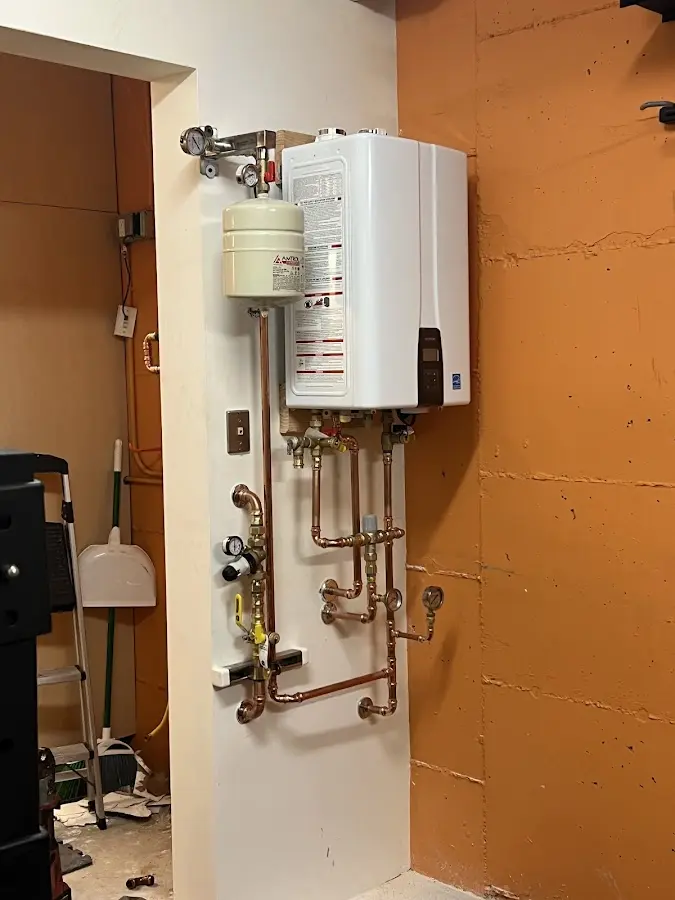 Plumbing technician inspecting water heater connections in Argyle